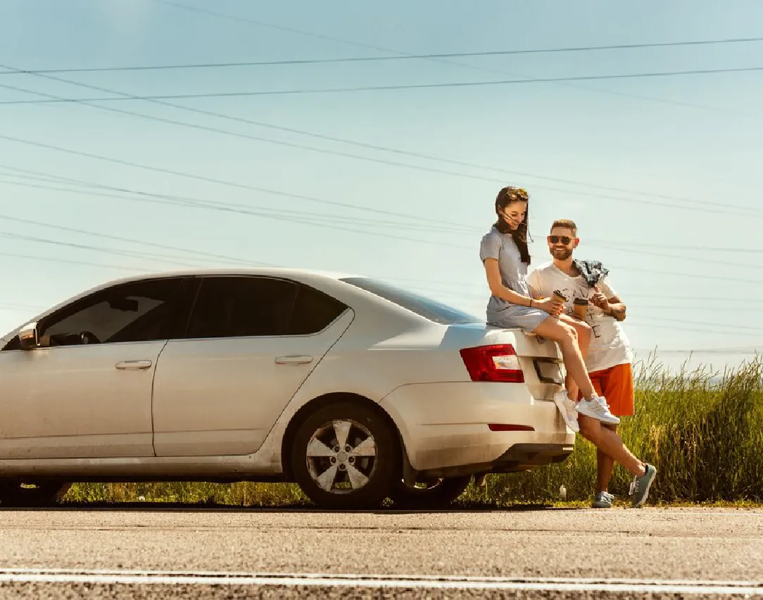 Una familia estacionada al lado del vehiculo