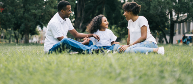 Familia sentados en el suelo de un parque