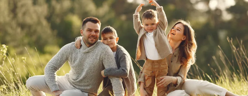 Familia de 4 integrantes sentados en el cesped